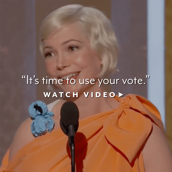 Blonde haired woman speaking into microphone wearing orange dress